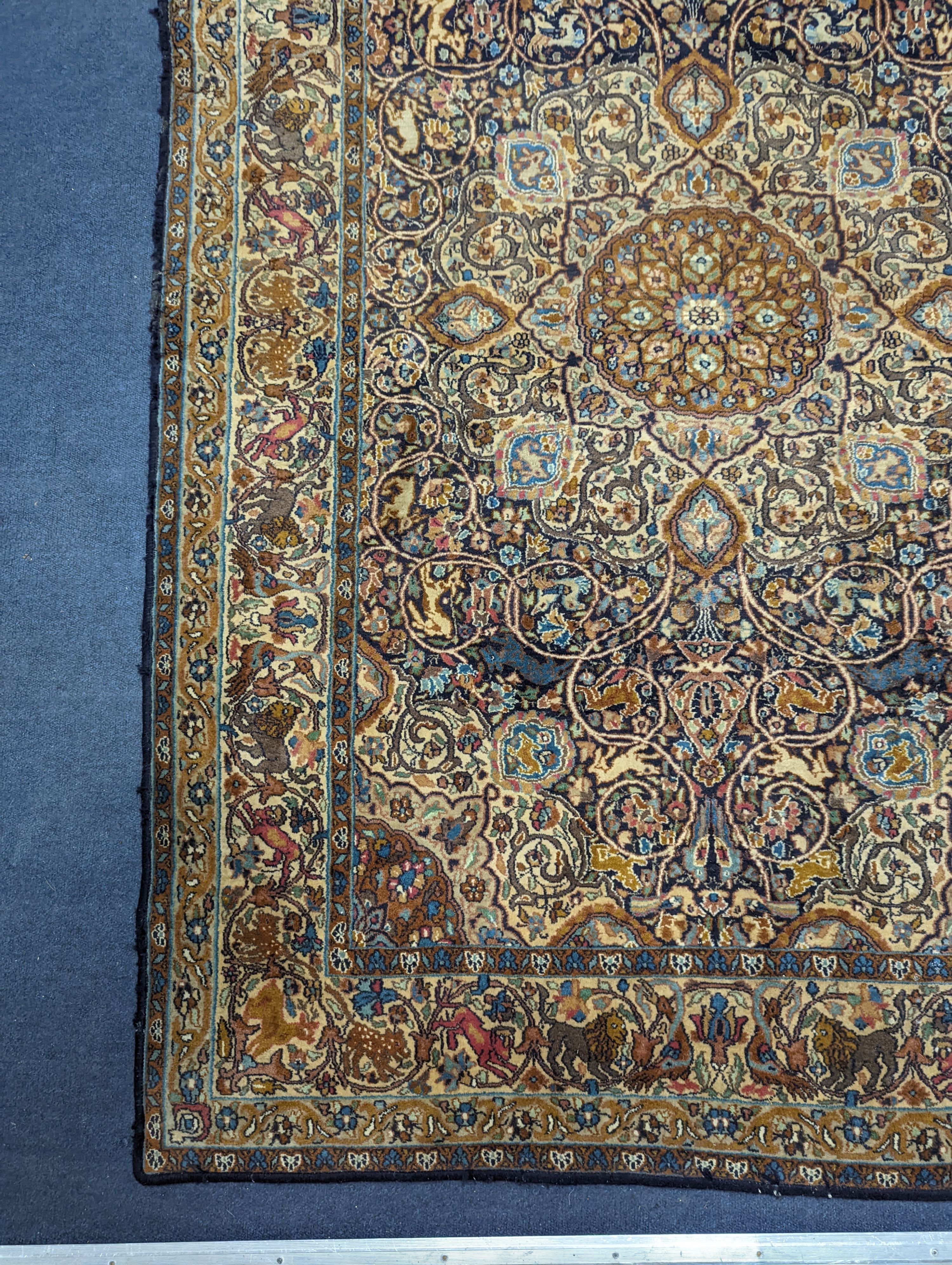 A Kashan blue ground rug woven with animals. 187x125cm.